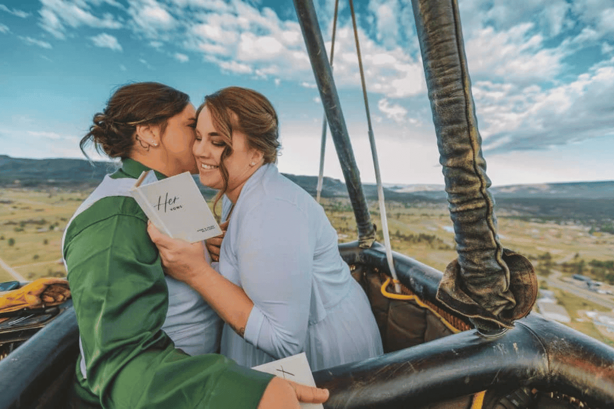 A woman reads her vows to her partner in a hot air balloon.